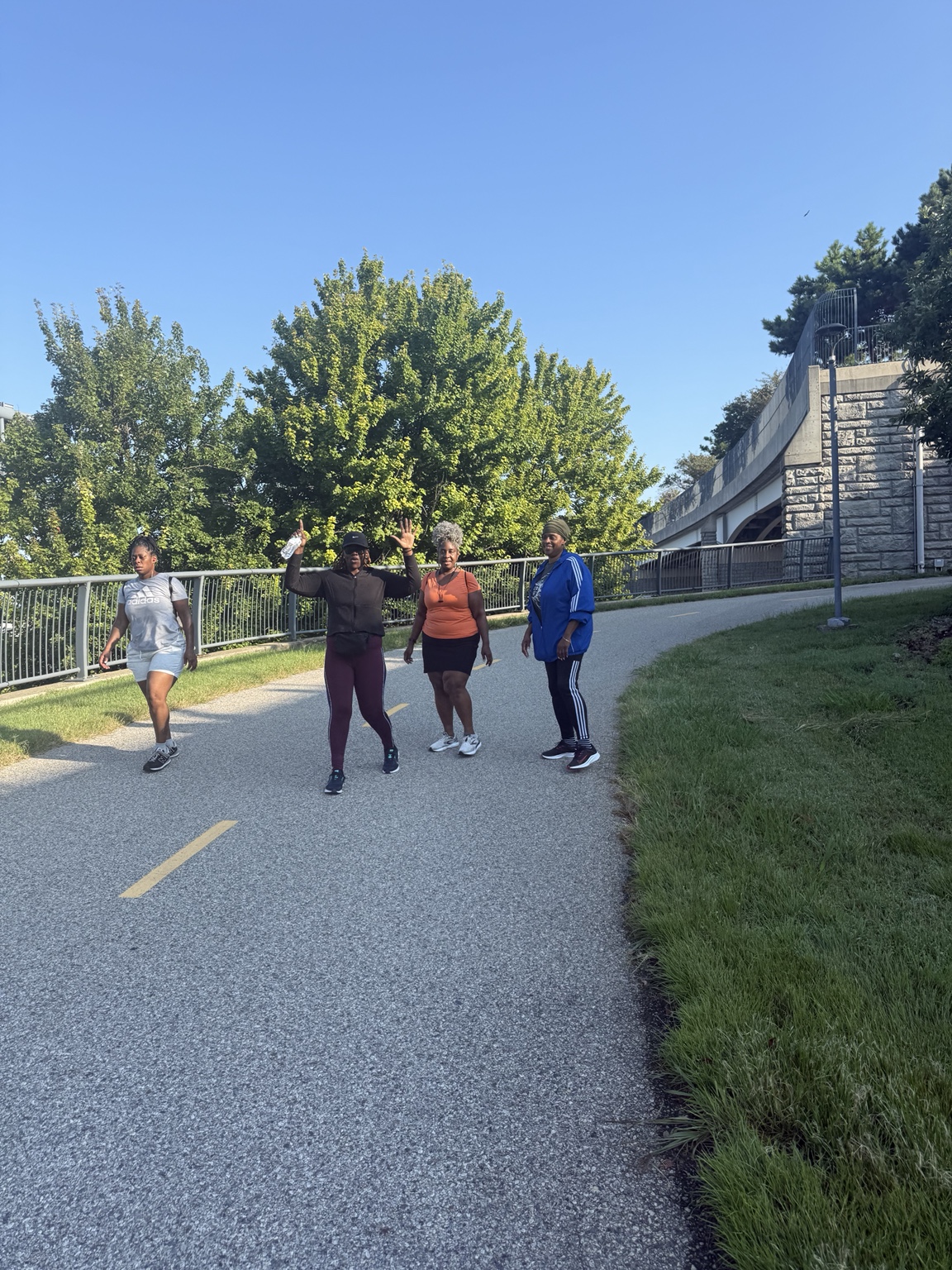 Four women walking together on the Woodrow Wilson Bridge Trail during the August 29, 2026 She Walks event.