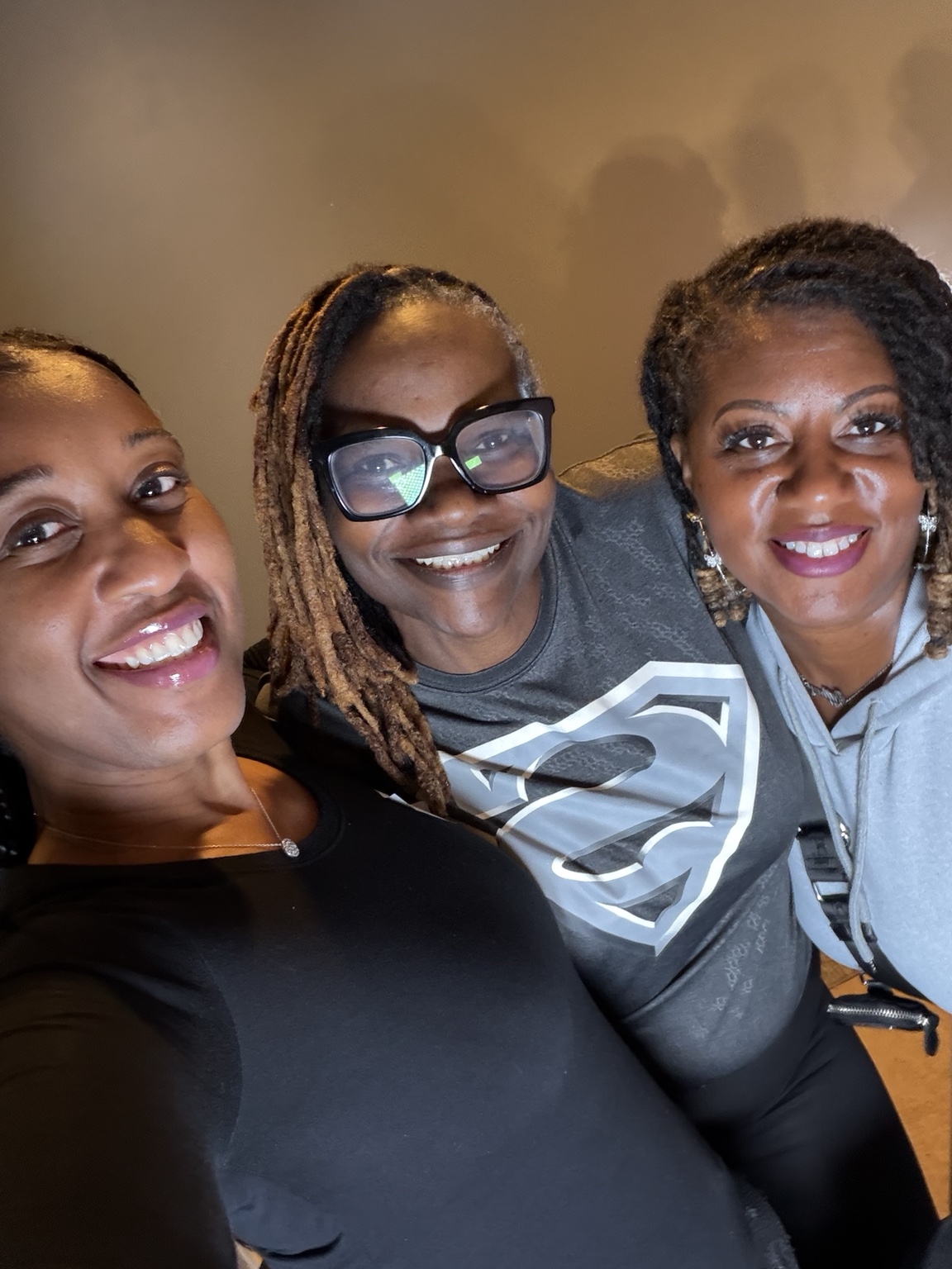 Three women smiling together at the Sacred Beads gathering.