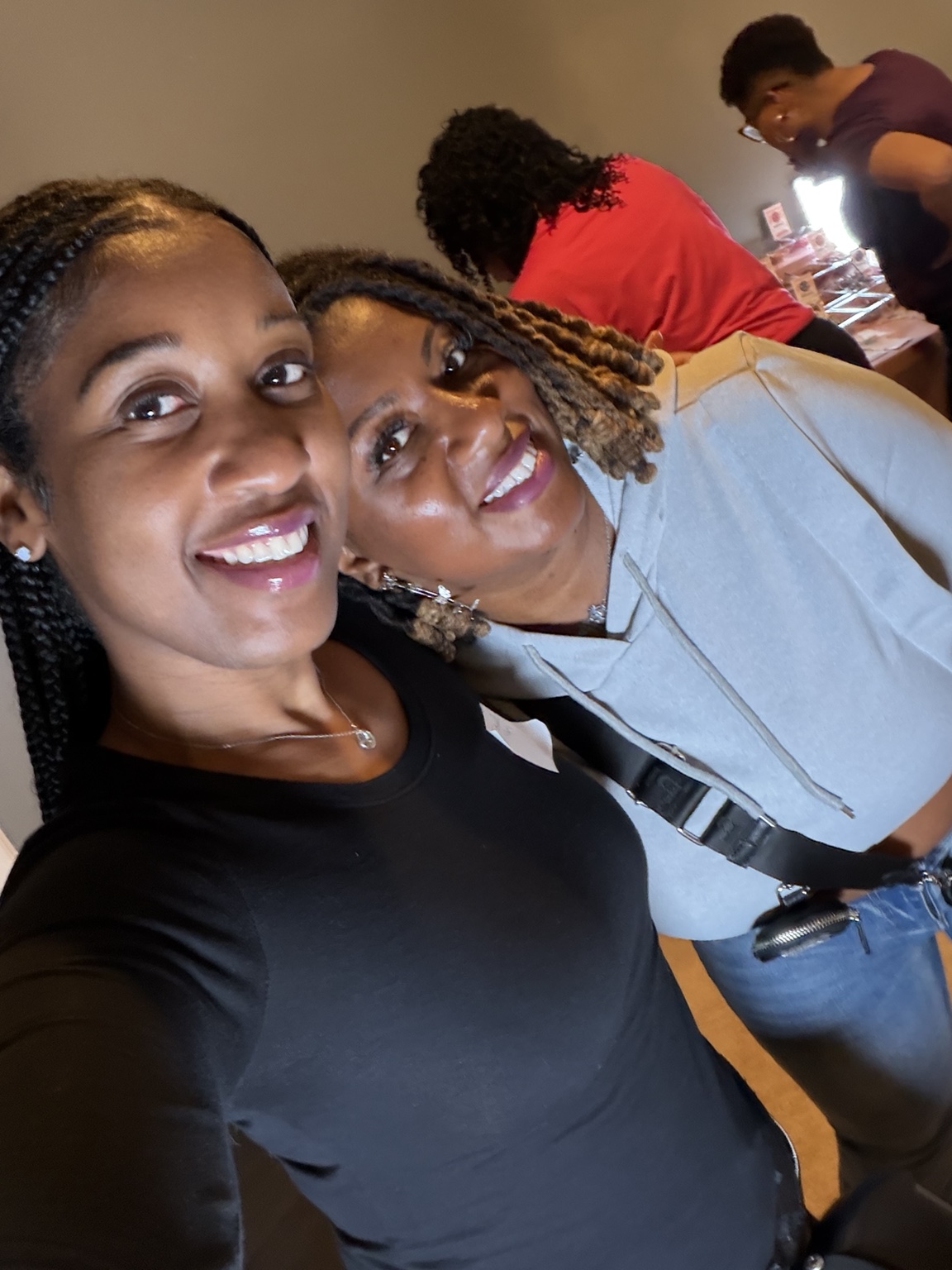 Two women smiling together during the Sacred Beads gathering.