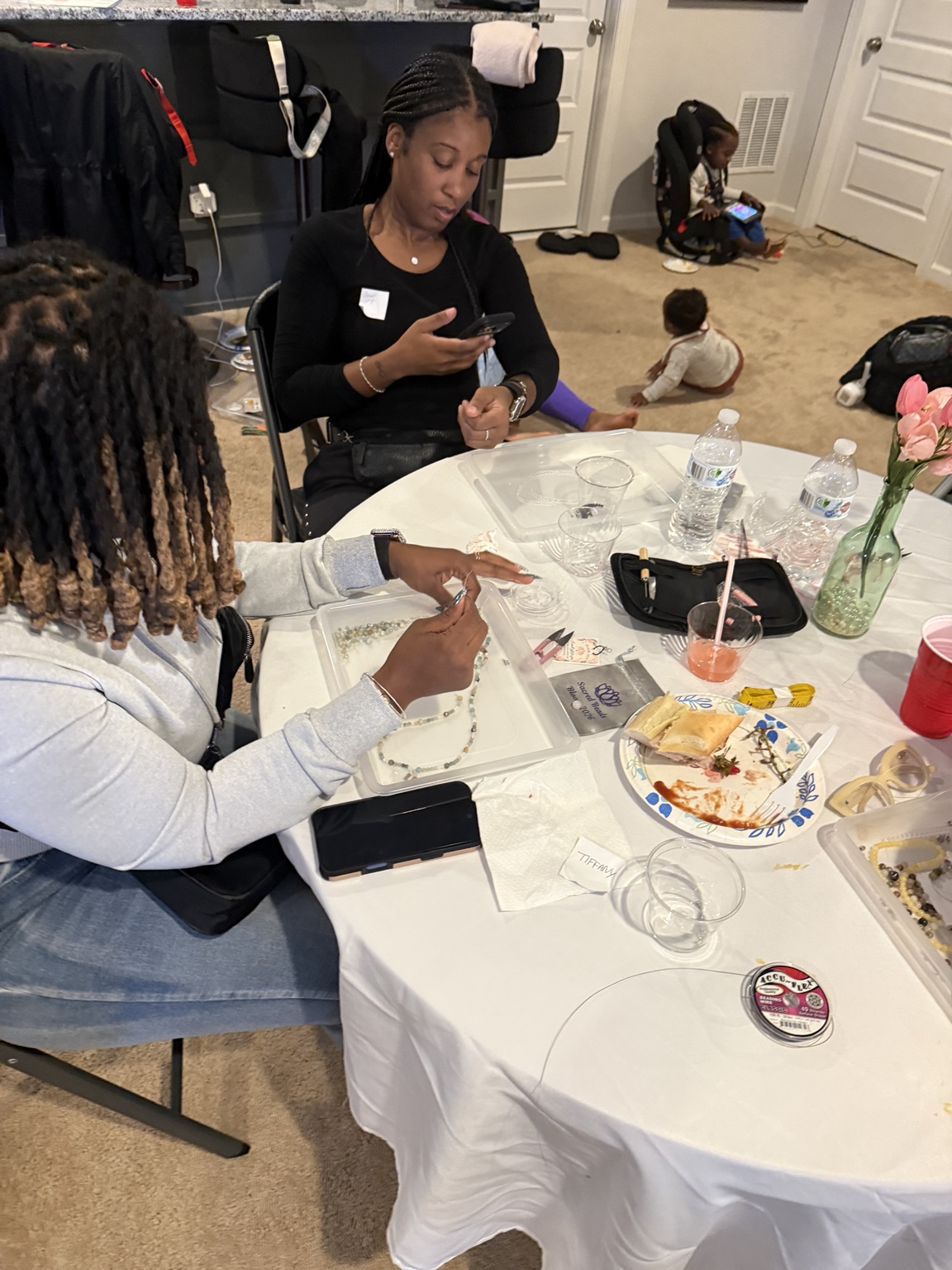 Guests creating beaded jewelry together at the Sacred Beads workshop table.
