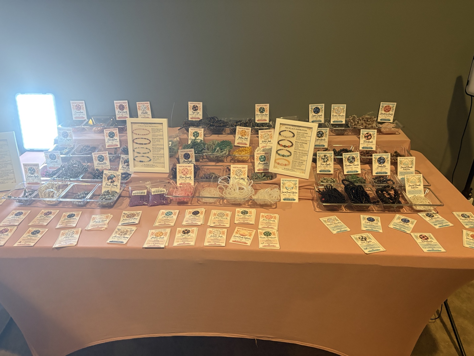 The Sacred Beads workshop table set with beads, cords, and information cards.